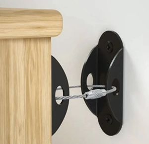 A table is secured to the wall with a black metal bracket and a metal cable.